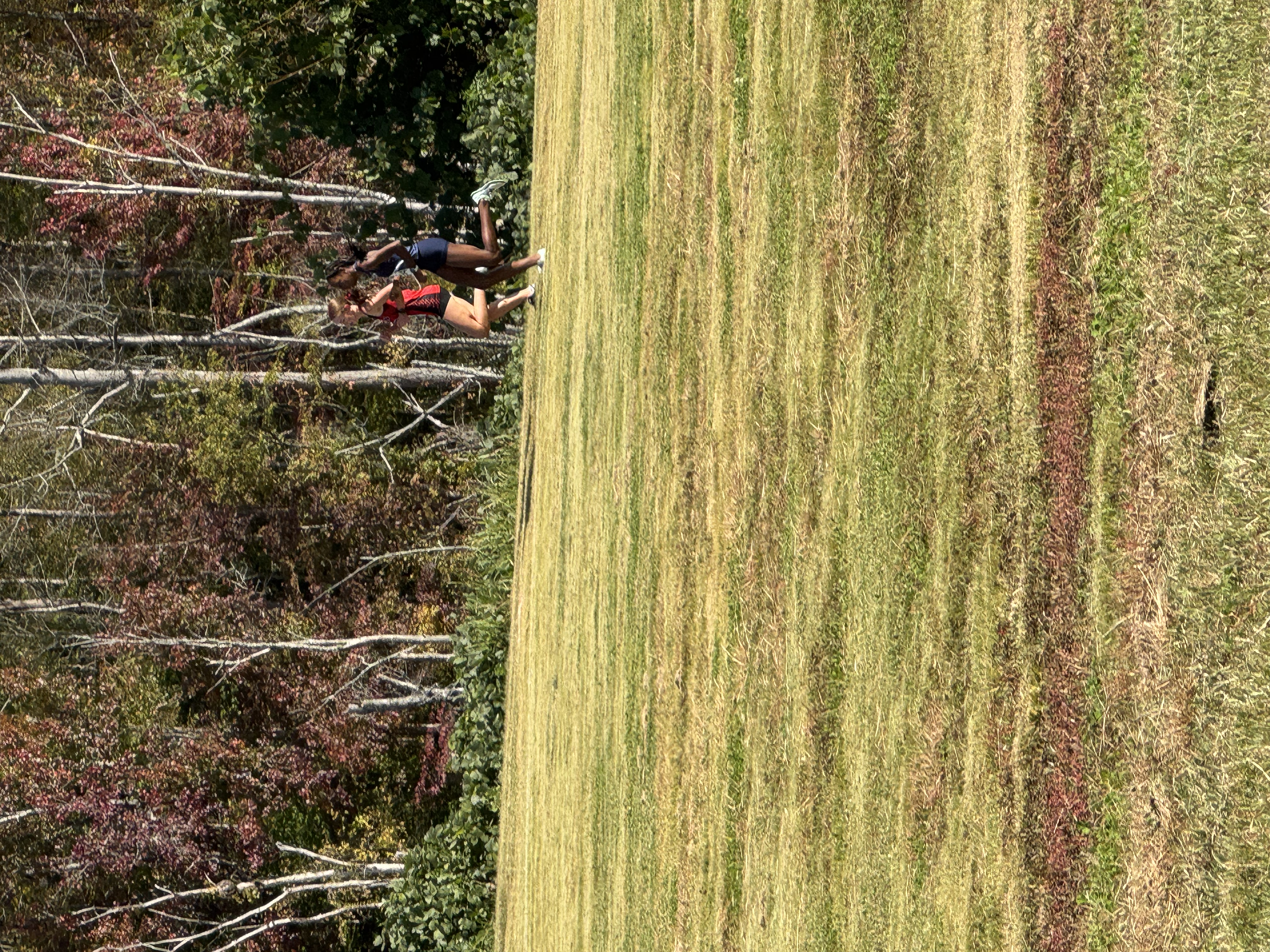 2 youth runners running in field